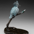 Photo of bronze sculpture of king fisher on branch next to dragon fly with granite base