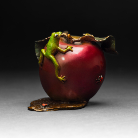 Photo of small bronze Sculpture featuring Tree Frog on two-toned apple with several insects