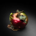 Photo of small bronze Sculpture featuring Tree Frog on two-toned apple with several insects