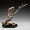 Photo of bronze Sculpture of Burrowing Owl on a branch eyeing a lizard with granite base