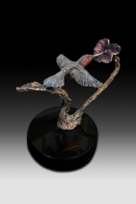 Bronze sculpture of humming bird feeding on a flower